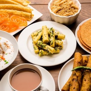 group-gujarati-snacks-like-jalebi-fafda-thepla-khaman-dhokla-aloo-bhujiya-khandvi-khakra-dahi-vada-gathiya-with-hot-tea_466689-34889